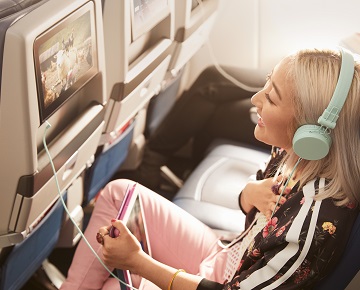 Girl laughing while watching a film on an airplane